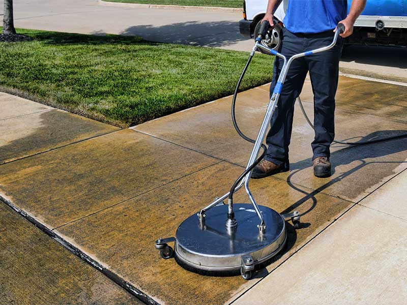 Man pressure washing his concrete driveway